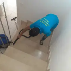 Un trabajador aspira escaleras para quitar polvo de obra.