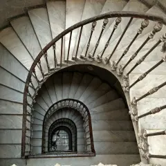 Escaleras de caracol de mármol con barandilla de hierro forjado. Un detalle de limpieza de escaleras de mármol revela su belleza clásica.