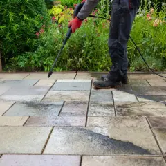 Persona realiza limpieza de patios con hidrolavadora, dejando las baldosas relucientes.