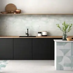 Cocina moderna con elegantes mosaicos de azulejos en paredes y barra. Tonos verdes y grises crean un ambiente fresco y sofisticado.