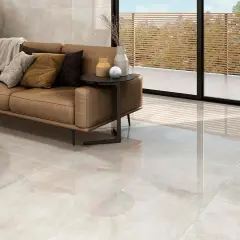 Elegante salón con sofá de cuero y suelo de gran formato, ideal para colocar baldosas.