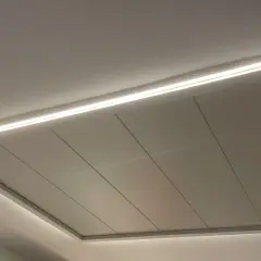 Un moderno falso techo con iluminación LED integrada, creando un ambiente acogedor.