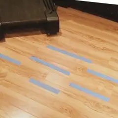 Marcando con cinta azul las áreas del parquet dañado por humedad para repararlo.