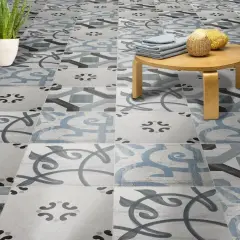 Un suelo hidráulico con un diseño de azulejos en tonos grises y azules, con un pequeño taburete de madera y una planta. ¡Perfecto para limpiar y lucir!