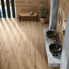 Baño moderno con suelo porcelánico imitando madera. Mueble de lavabo doble con lavabos sobre encimera y grifería negra.