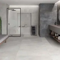 Baño moderno con ducha, lavabo doble y banco. Paredes y suelo revestidos con elegante material gres en tonos grises y oscuros.