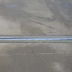 Una junta de dilatación metálica atraviesa el suelo de hormigón, permitiendo el movimiento natural de la estructura.