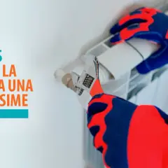 Manos con guantes ajustando una llave inglesa en un radiador, para solucionar la presión de la caldera alta.