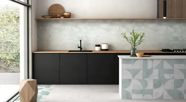 Cocina moderna con elegantes mosaicos de azulejos en paredes y barra. Tonos verdes y grises crean un ambiente fresco y sofisticado.