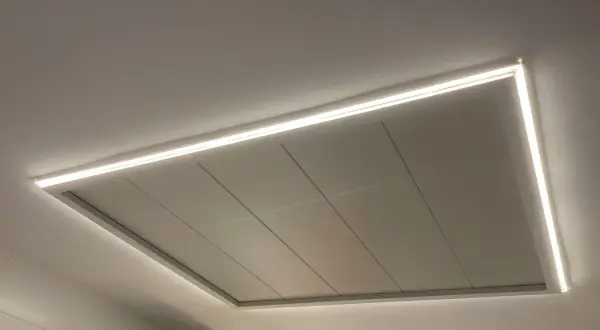 Un moderno falso techo con iluminación LED integrada, creando un ambiente acogedor.