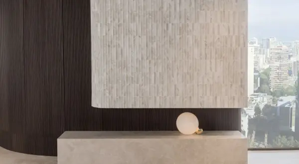 Detalles de cómo revestir una pared con azulejos de mármol y paneles oscuros, creando un diseño moderno.