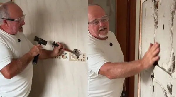 Hombre con gafas de seguridad usando un martillo y cincel para quitar azulejos de una pared.
