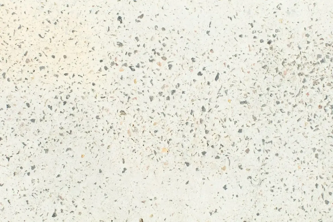 Suelo de terrazo con incrustaciones de piedra gris y beige. ¿Cuánto cuesta pulir un suelo de terrazo?