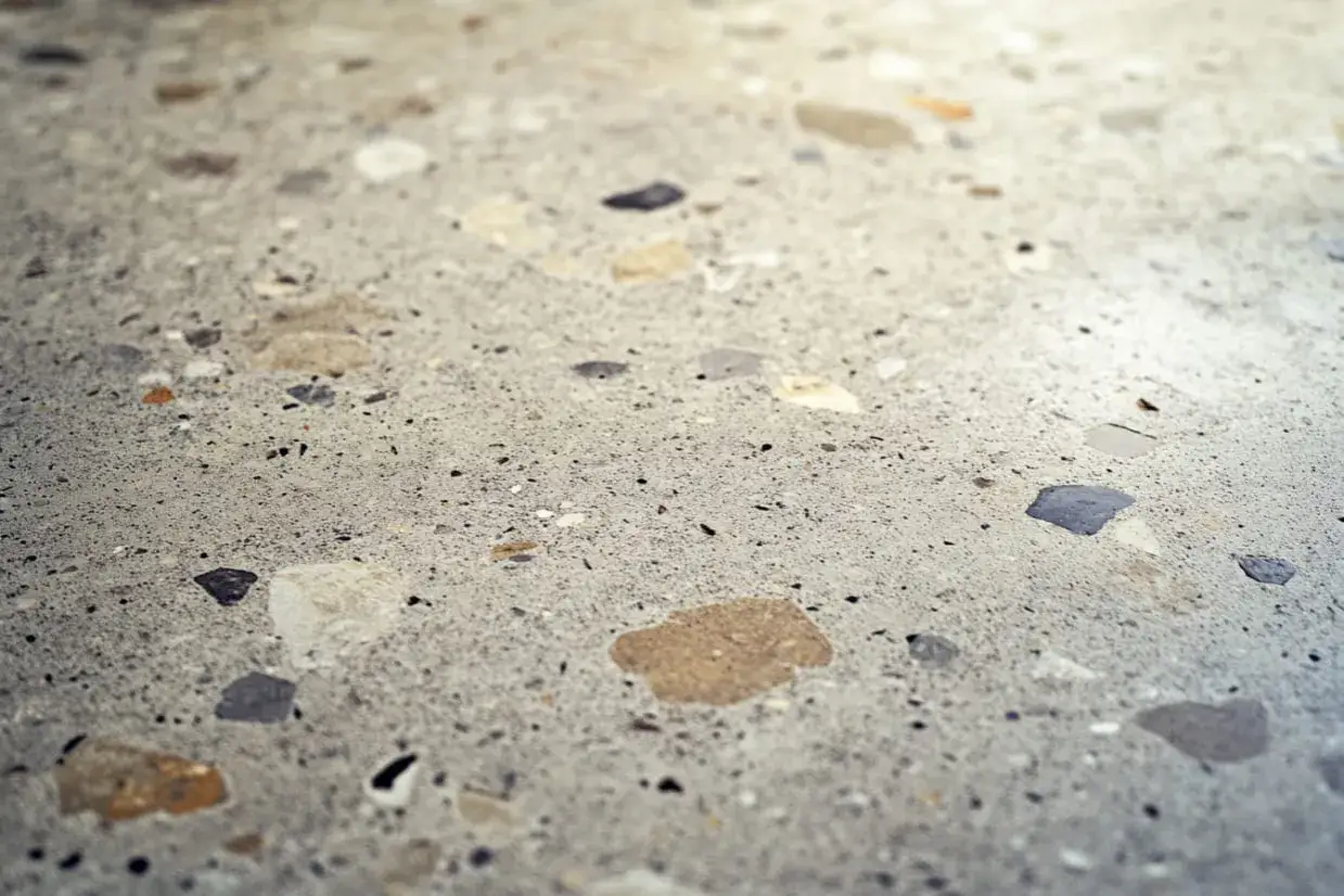 Detalle de un suelo terrazo reci&eacute;n pulido, mostrando la textura y los fragmentos de piedra incrustados.