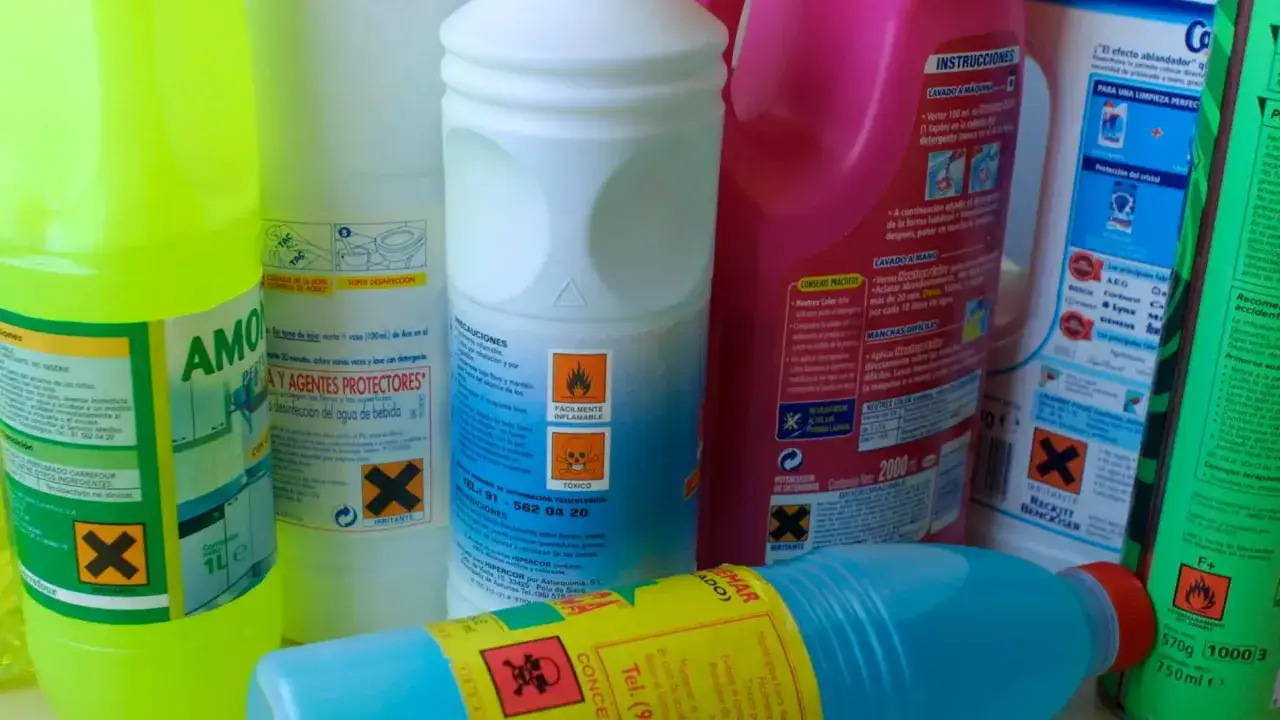 Botellas de lej&iacute;a y otros productos de limpieza. Una botella verde lima con la etiqueta 