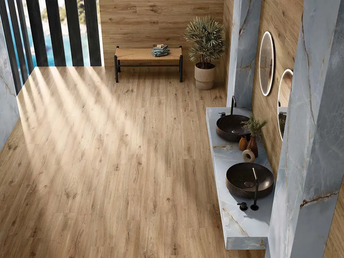 Baño moderno con suelo porcelánico imitando madera. Muestra diferentes formas de colocar suelo porcelanico, creando un ambiente cálido y elegante.