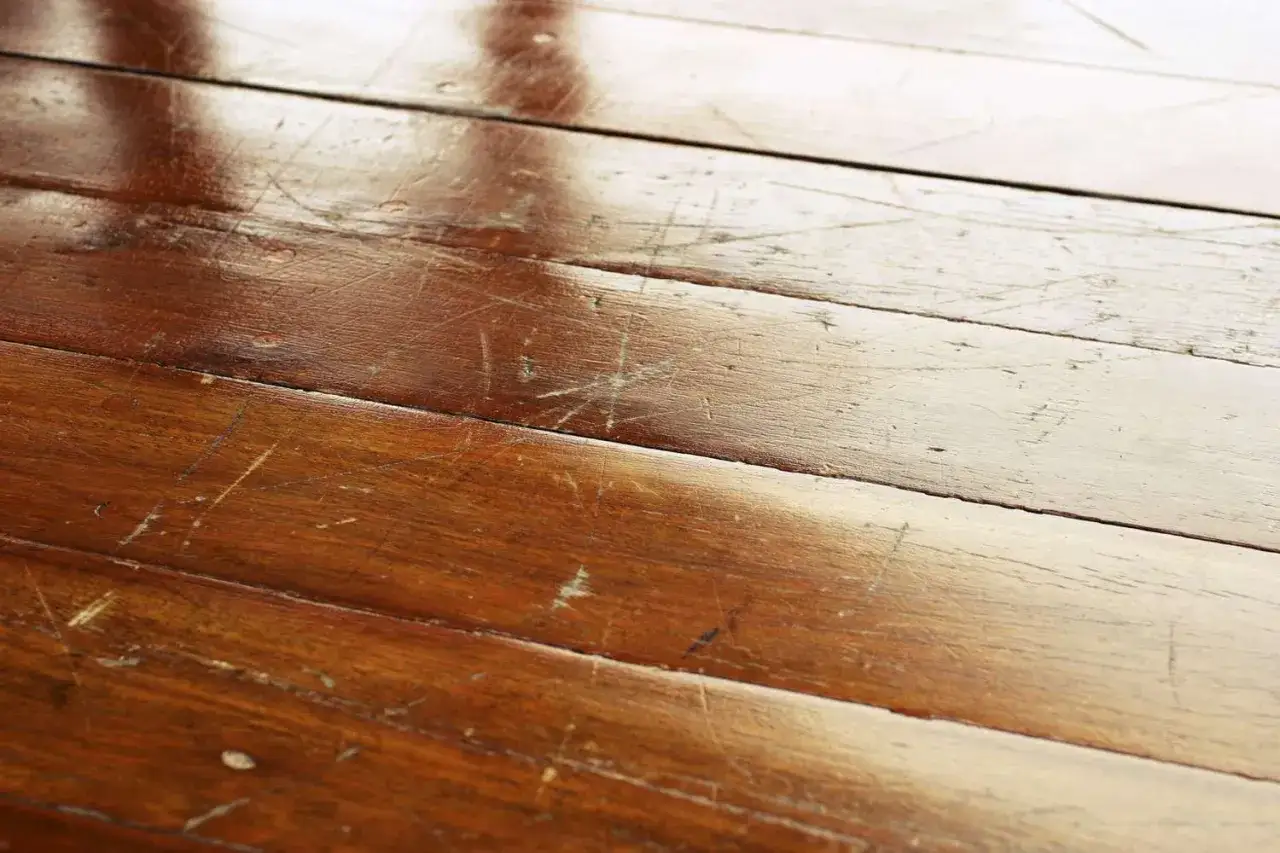 Parquet de madera con ara&ntilde;azos y desgaste. Aprende como cambiar parquet estropeado para renovar tu hogar.