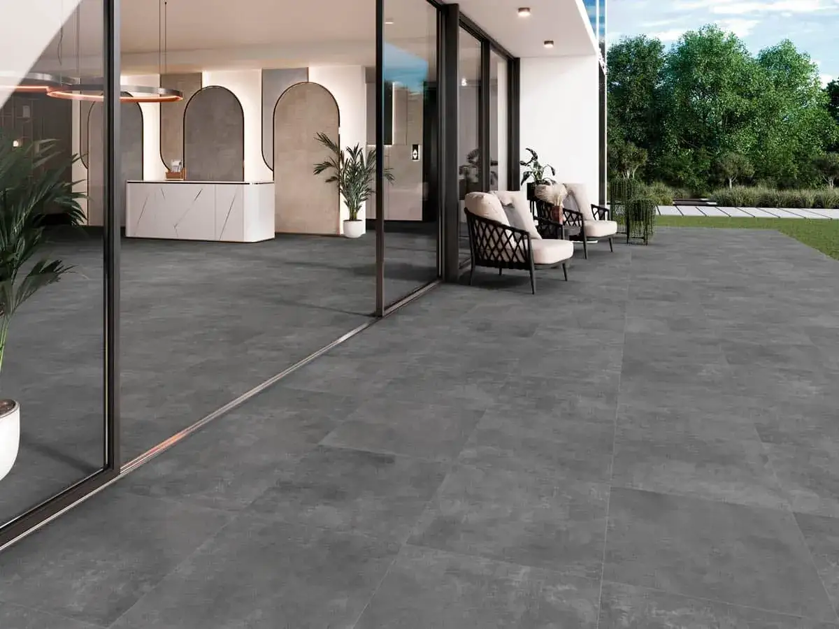 Modern terraza con suelo exterior sobre cemento, sillas de mimbre y plantas. Interior con recepci&oacute;n elegante.