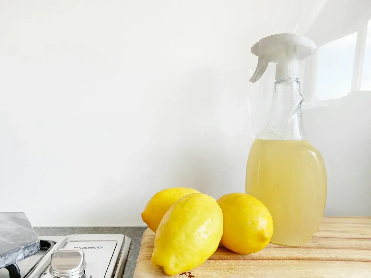 Limones y un pulverizador con l&iacute;quido casero, ideal para saber como quitar la cal de los cristales de forma natural.