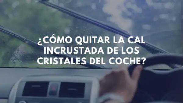 ¿Cómo quitar la cal incrustada de los cristales del coche? Imagen muestra el interior de un coche con limpiaparabrisas en acción.