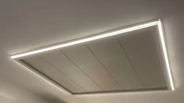 Un moderno falso techo con iluminación LED integrada, creando un ambiente acogedor.