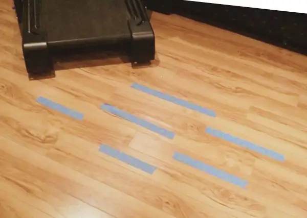 Marcando con cinta azul las áreas del parquet dañado por humedad para repararlo.